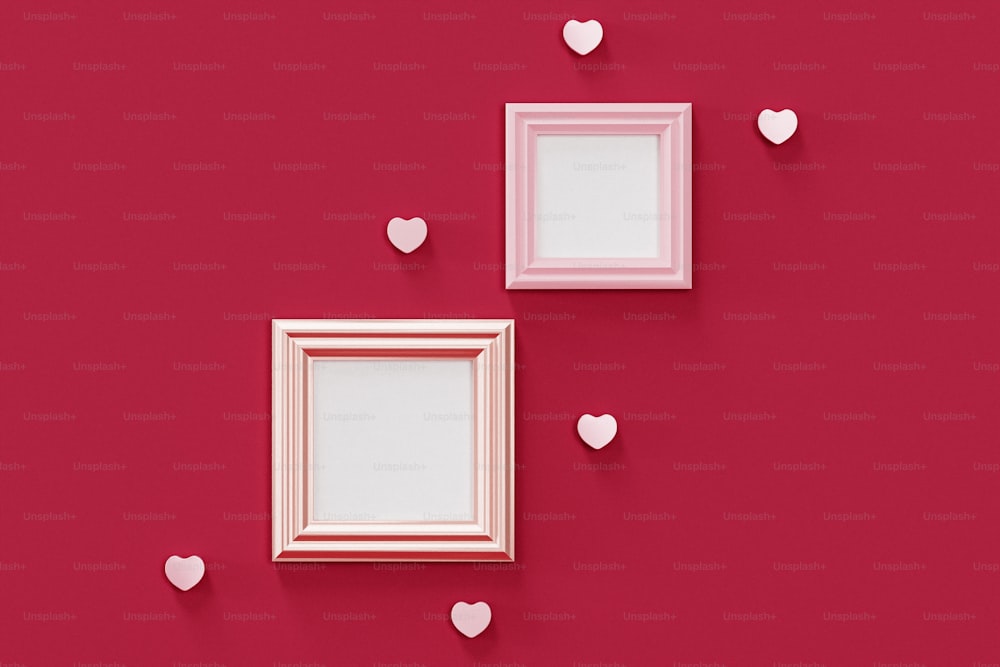 two frames with hearts on a red wall