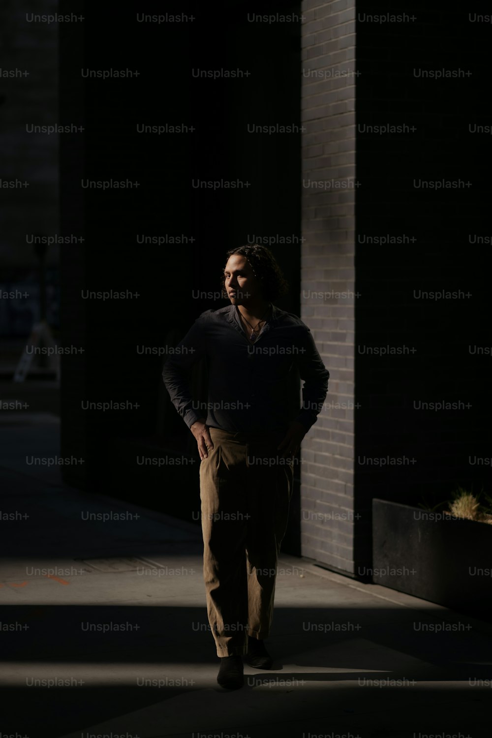 um homem de pé em uma calçada no escuro