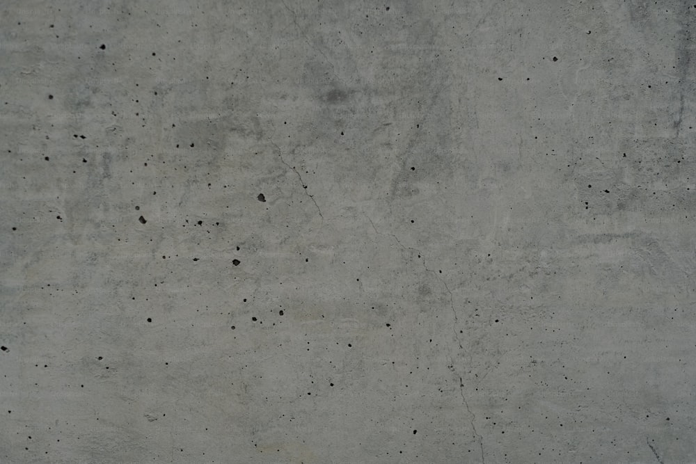 a concrete wall with small black dots on it