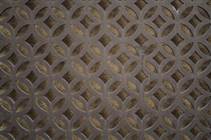 Un primer plano de una rejilla de metal con círculos en ella