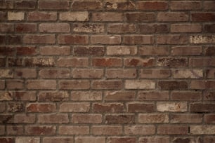 Un idrante rosso seduto sul lato di un muro di mattoni