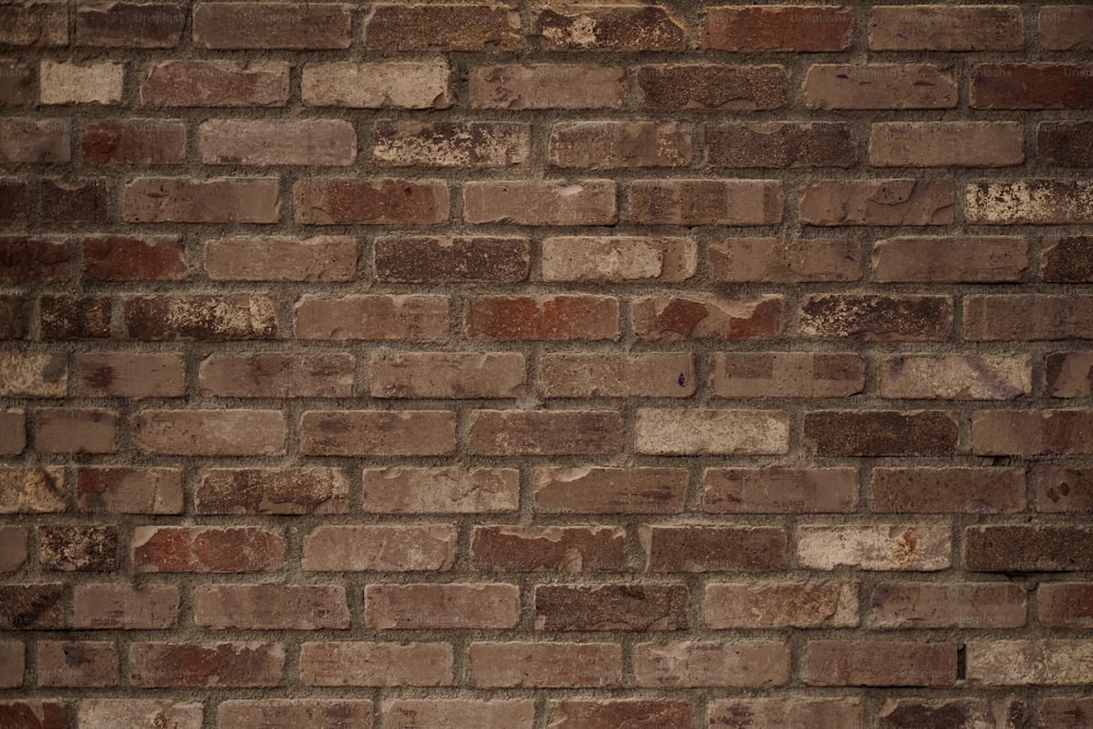 a red fire hydrant sitting on the side of a brick wall