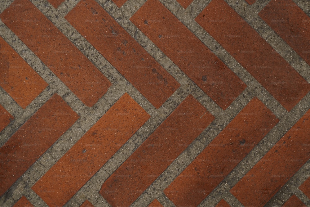 Un primo piano di un pavimento di mattoni rossi e grigi