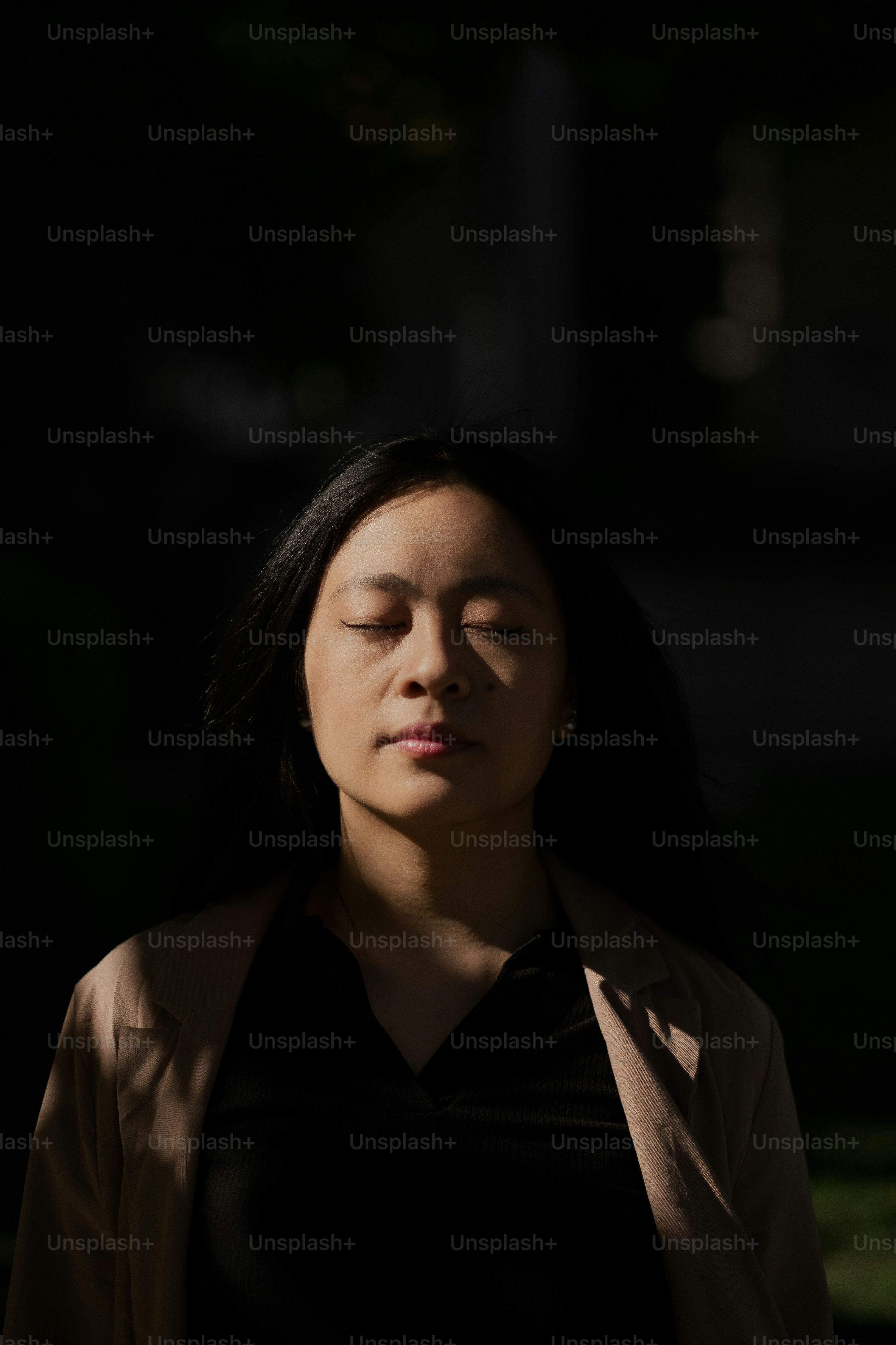 seorang wanita dengan mata tertutup dalam kegelapan