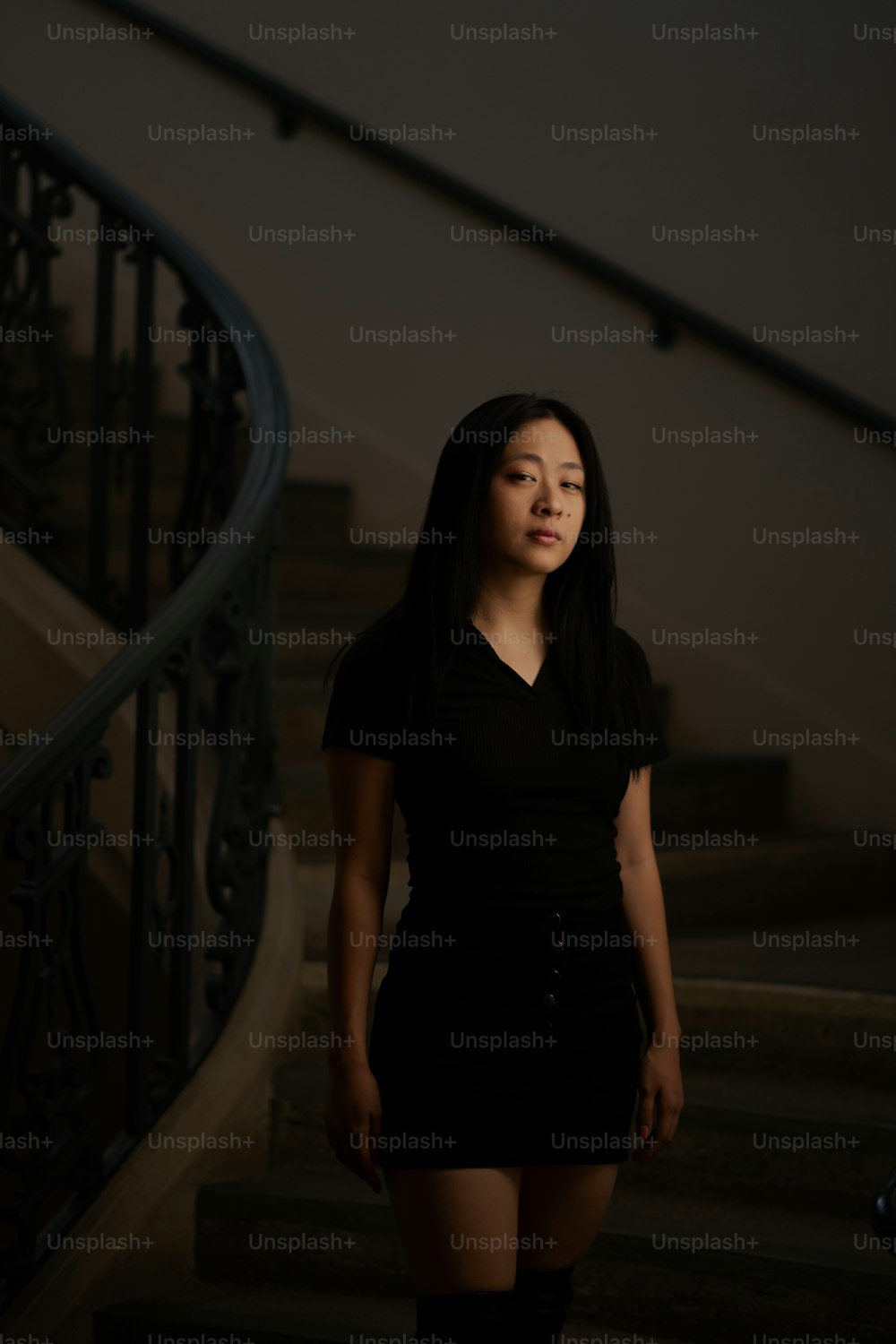 a woman standing in front of a set of stairs