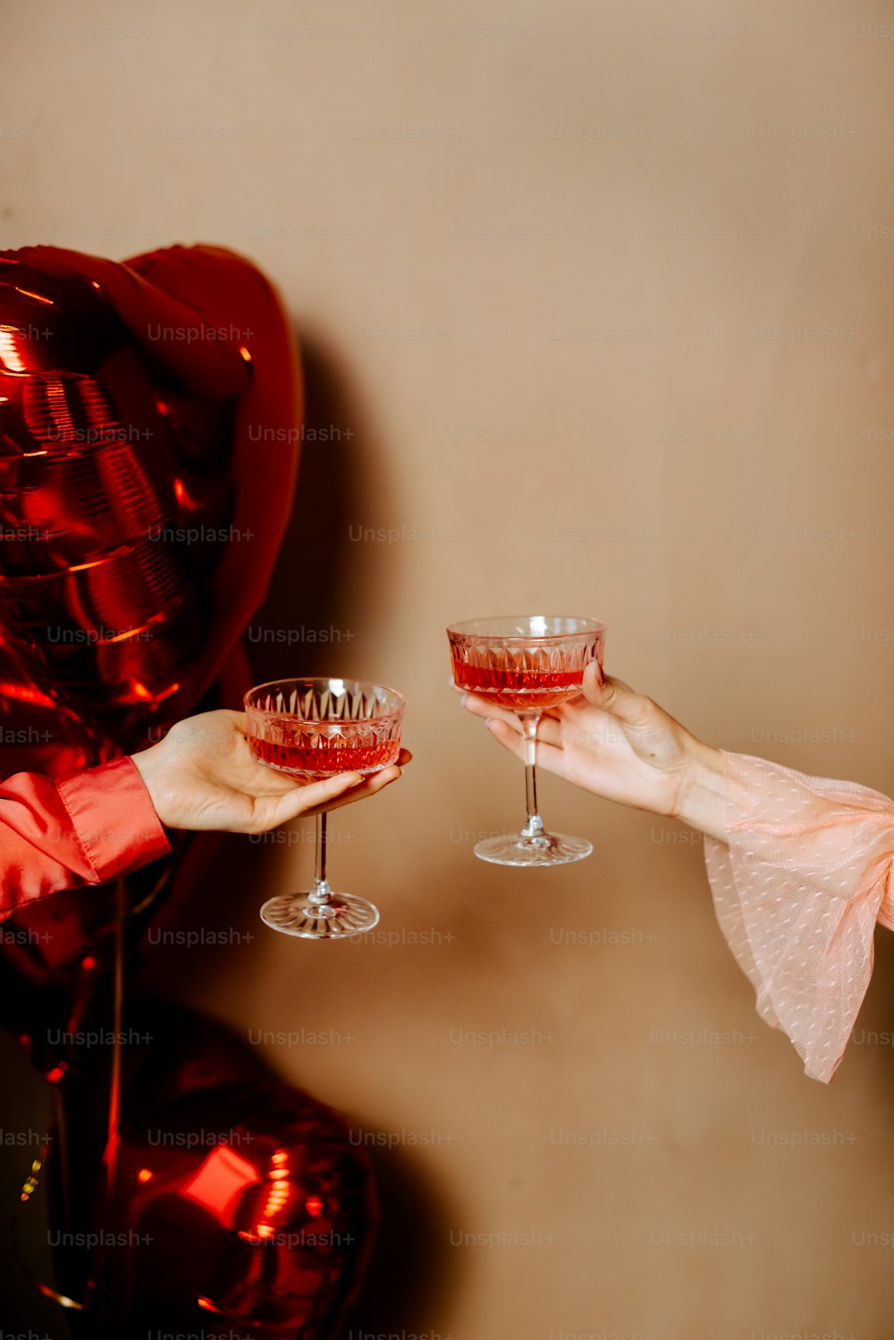 uma pessoa segurando um copo de vinho na frente de um balão