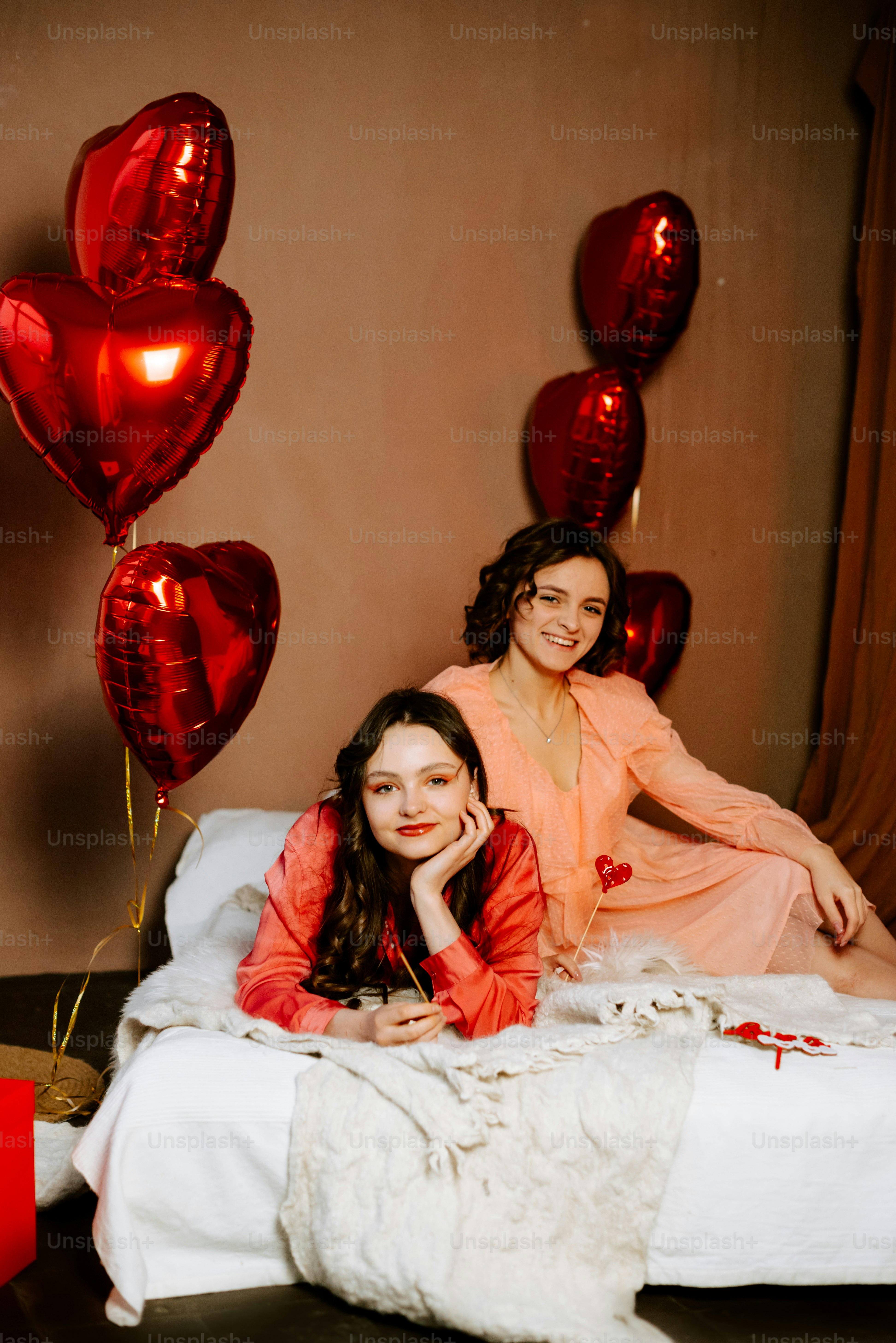 a couple of women laying on top of a bed