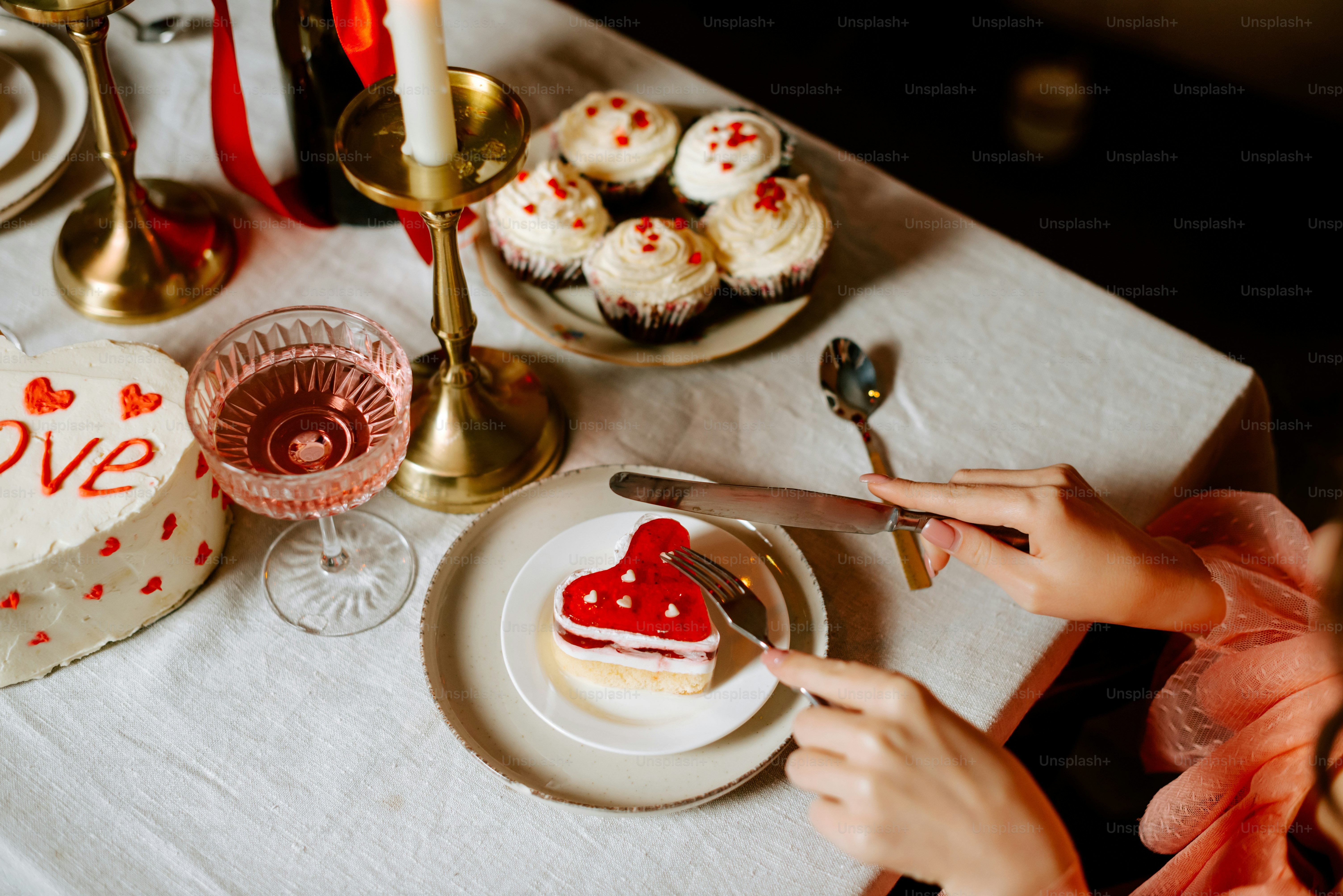 a person cutting a heart shaped cake on a table