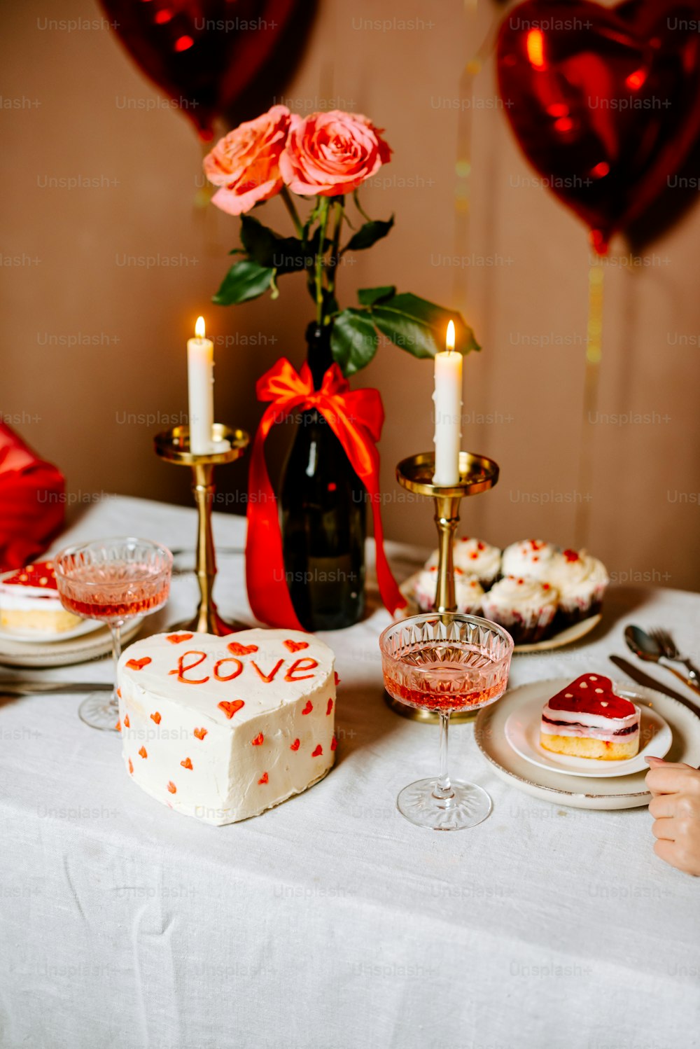 una mesa cubierta con un pastel junto a una botella de vino