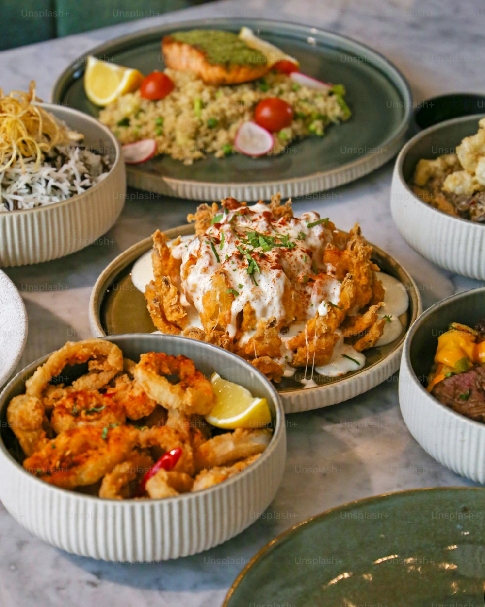 a table topped with bowls of food and plates of food