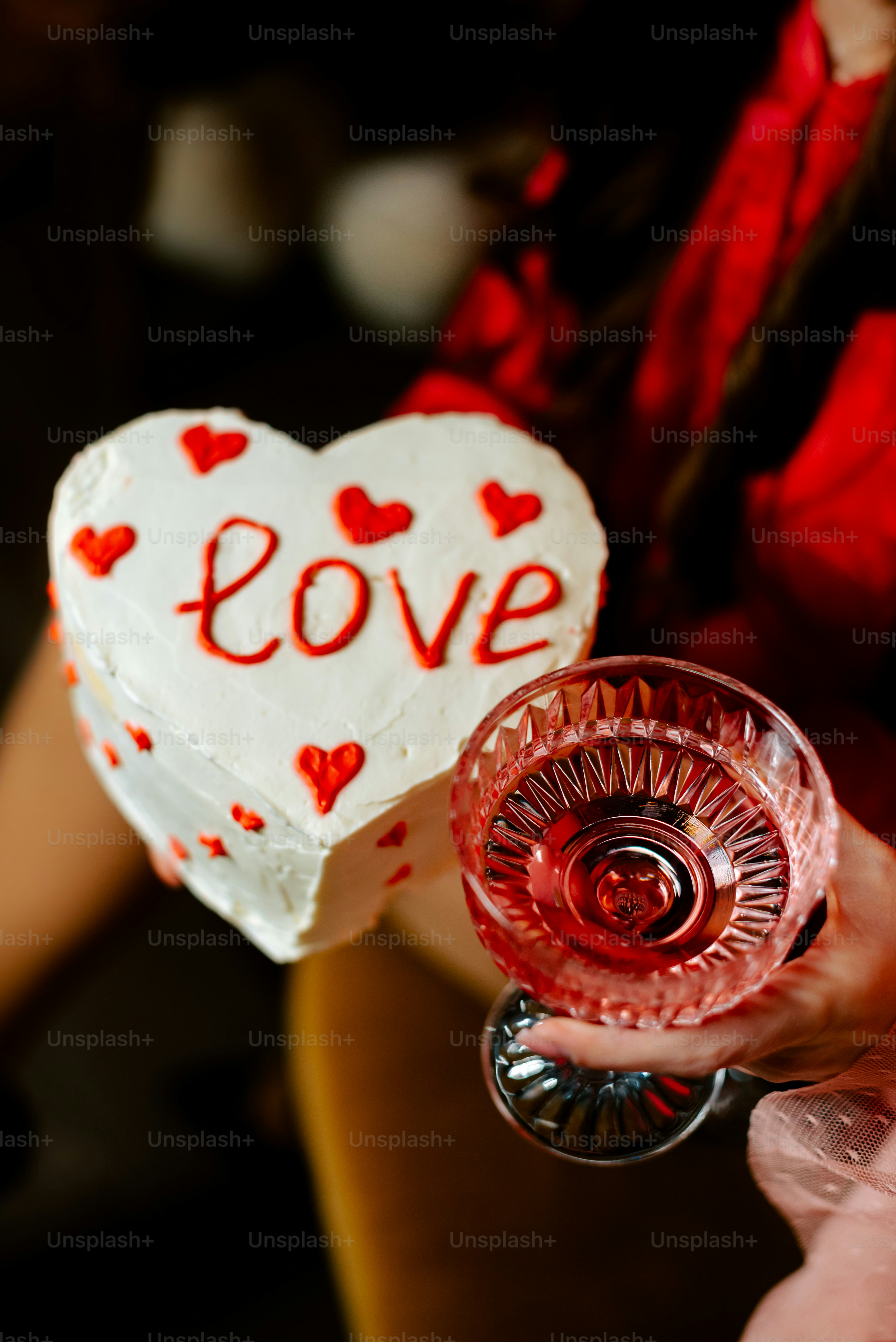 a person holding a heart shaped cake in their hand