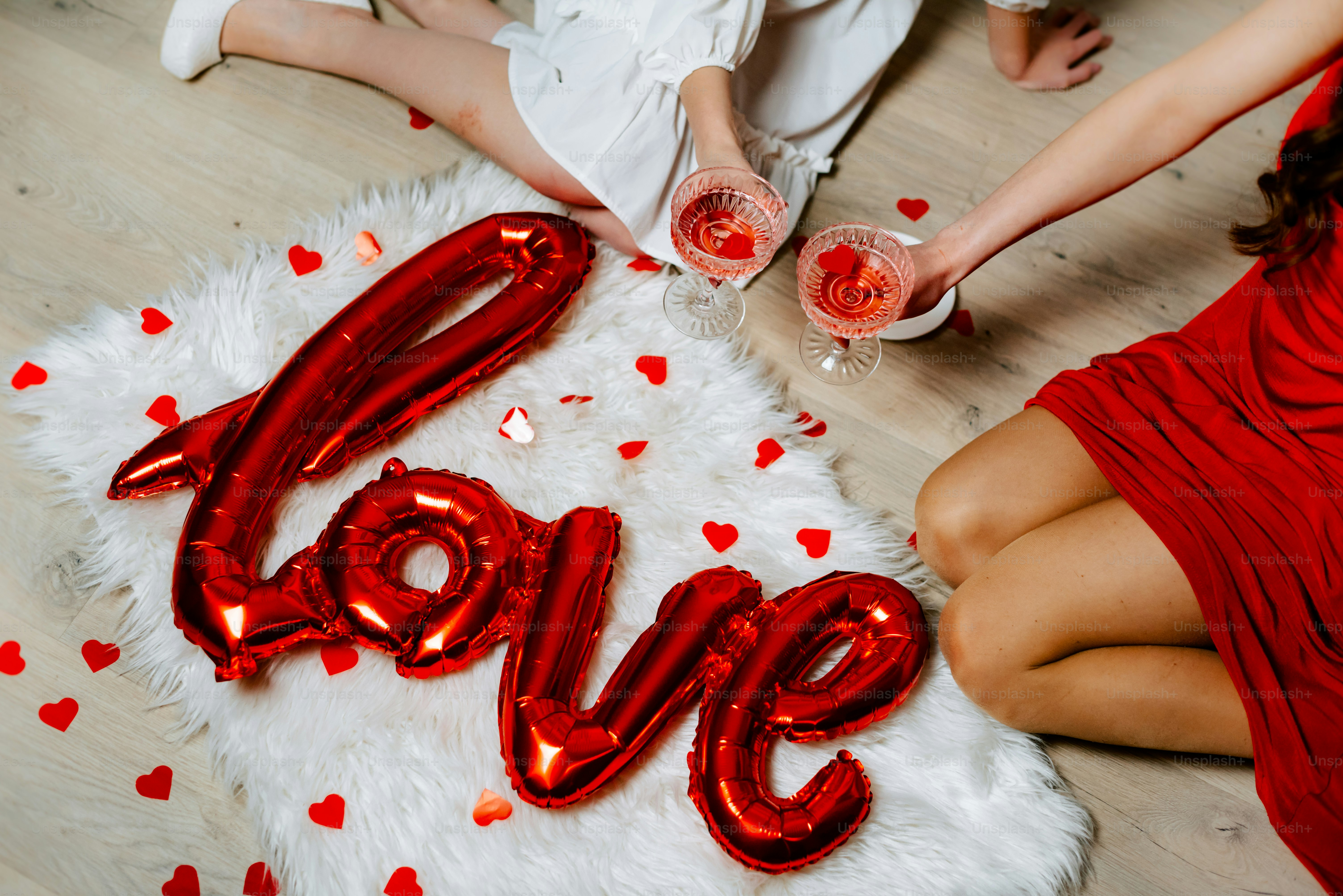 a couple of people sitting on a floor holding glasses