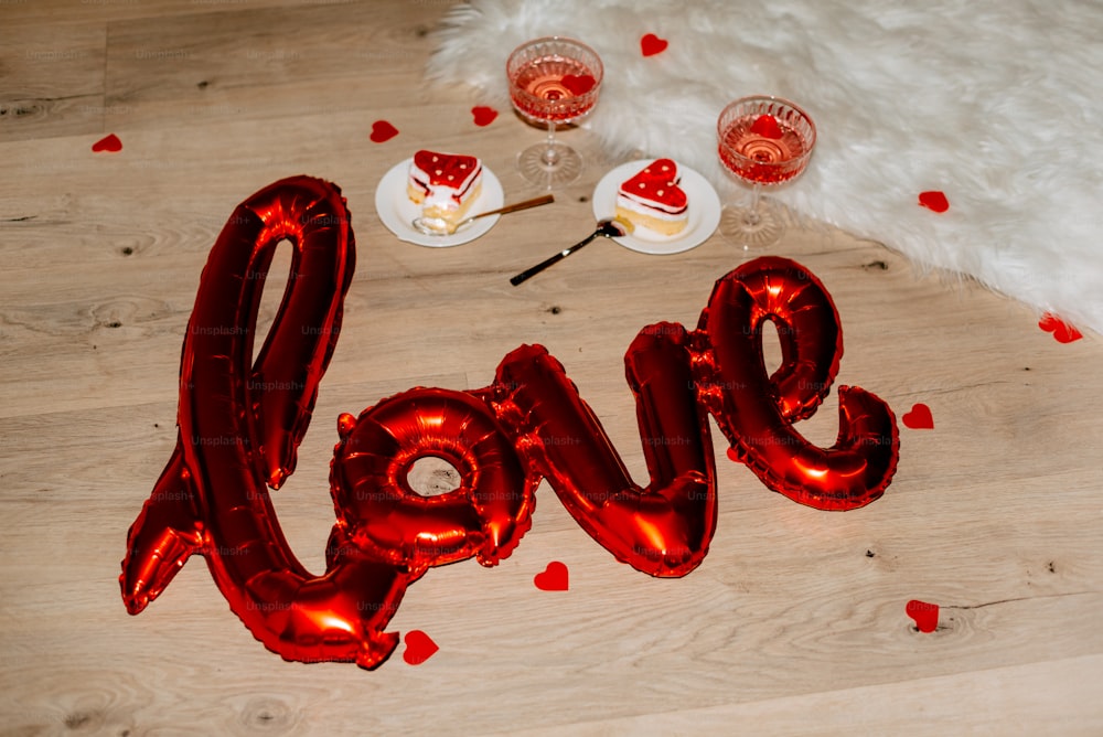 a red love balloon sitting on top of a wooden floor