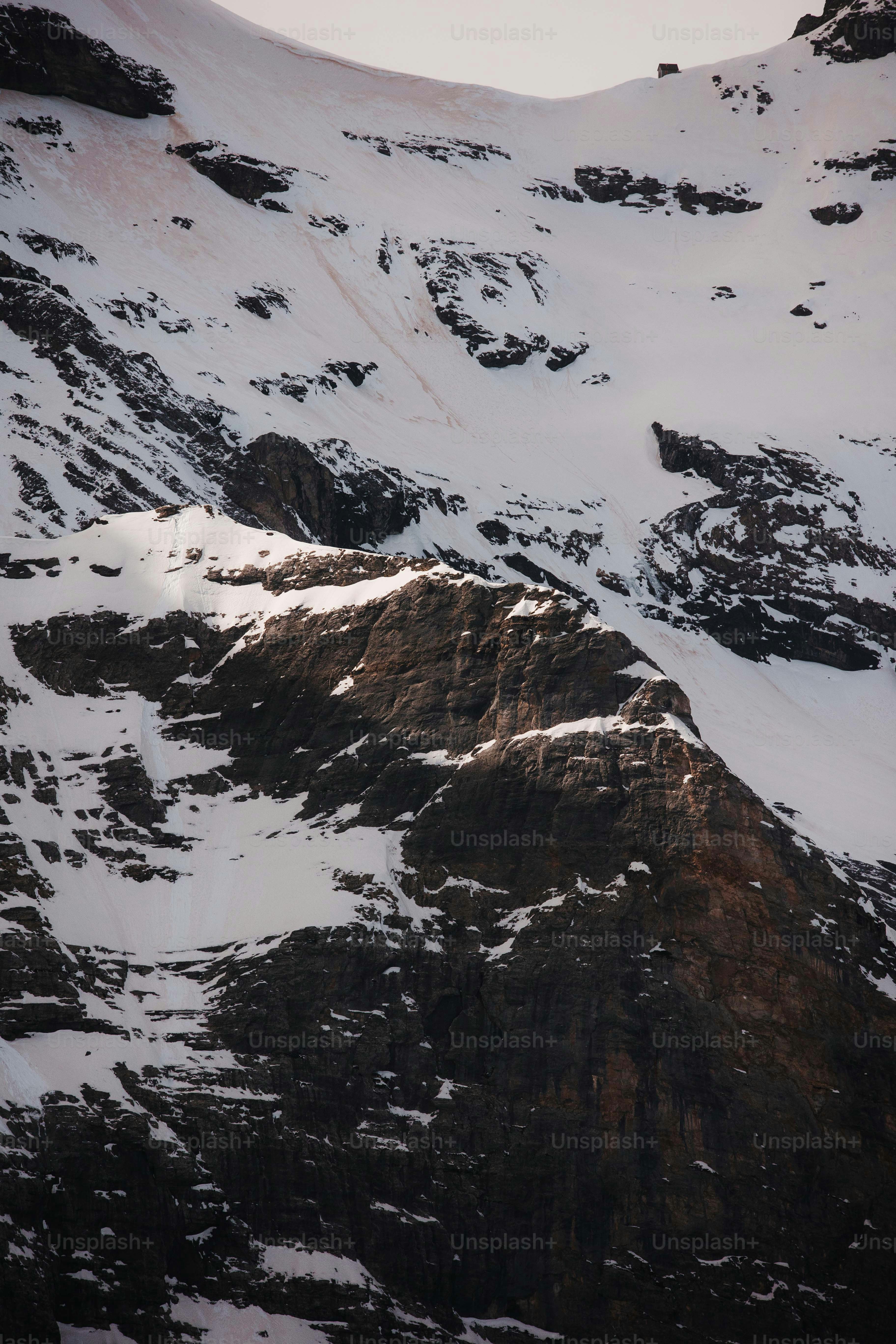 a mountain covered in snow with a sky background