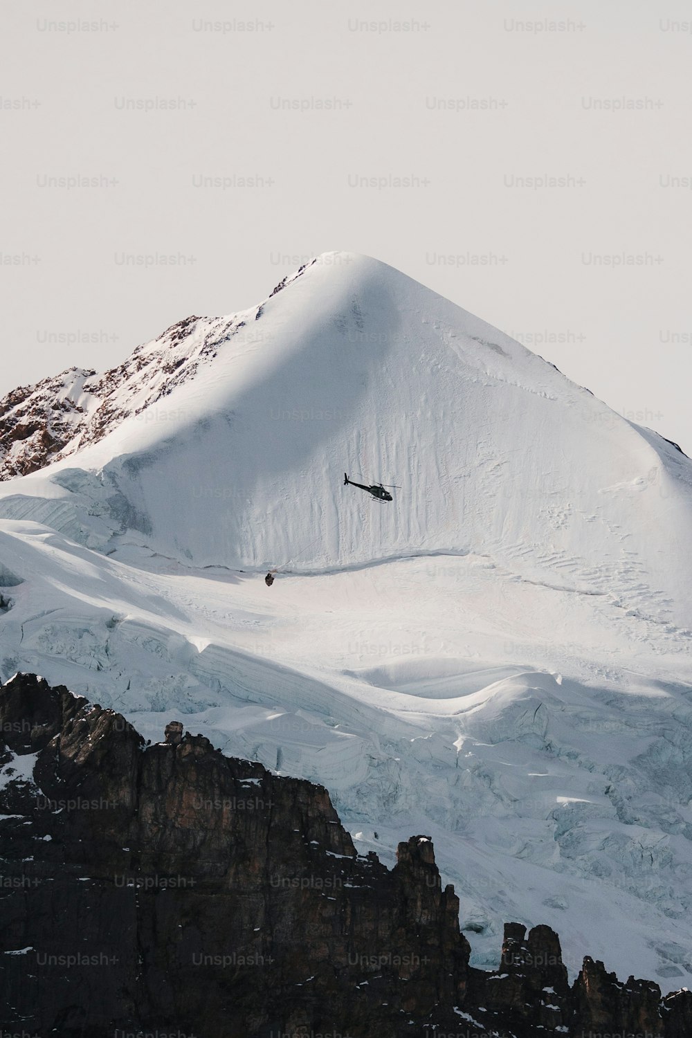 Uno snowboarder sta saltando giù da una montagna innevata