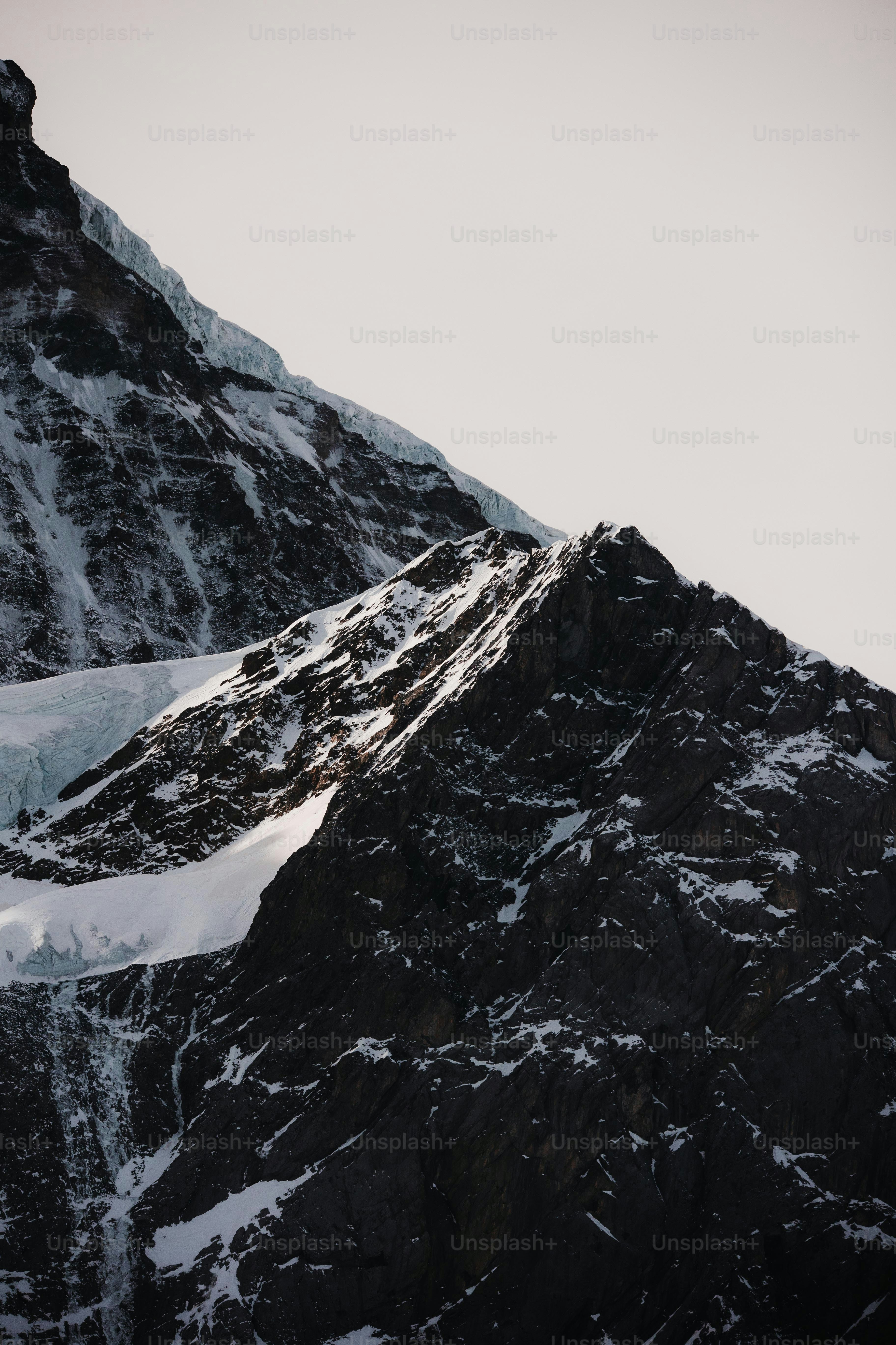 a snowboarder is going down a snowy mountain