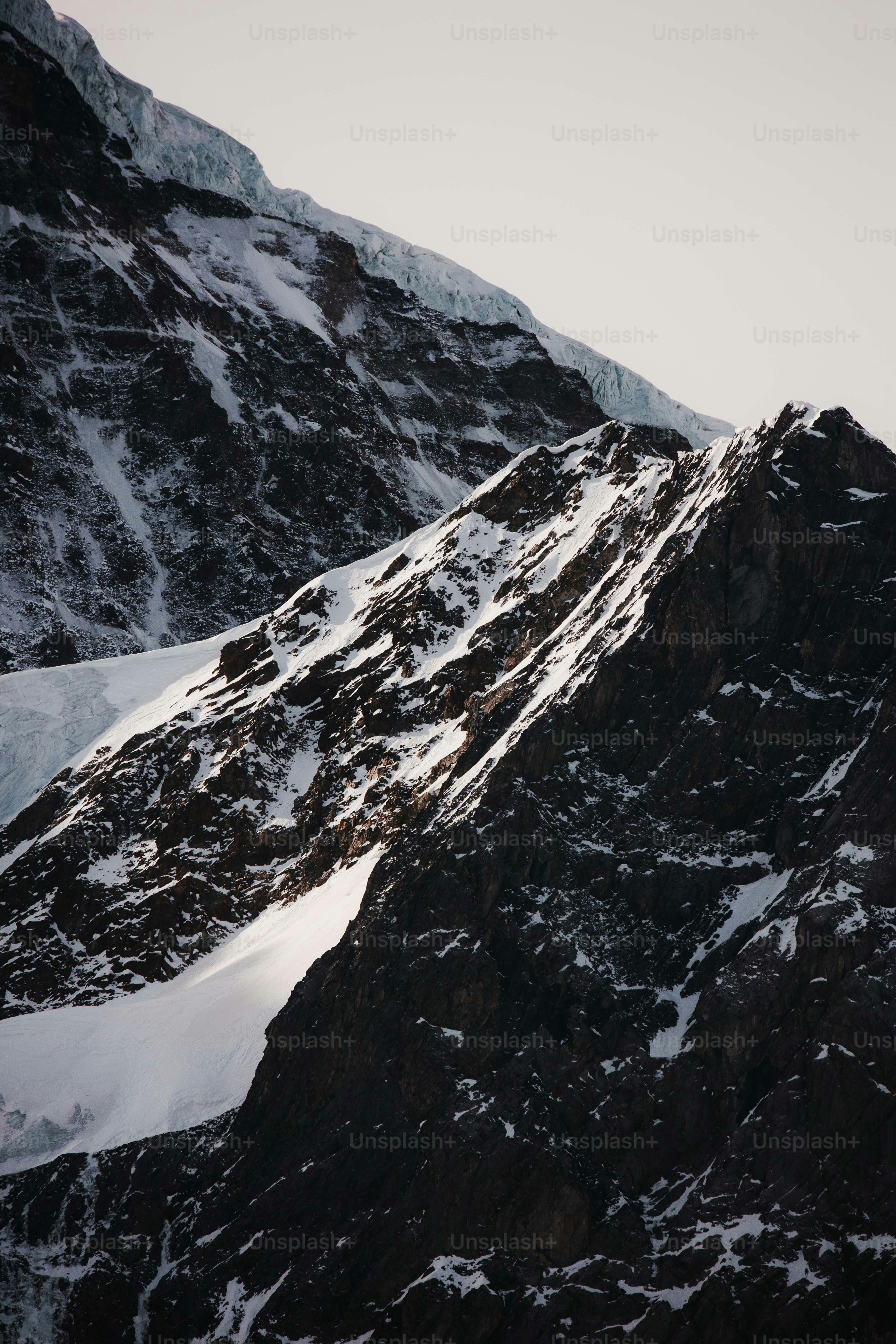 a snowboarder is going down a snowy mountain