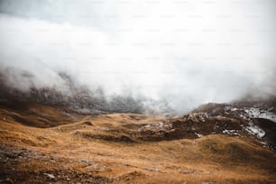 a mountain covered in fog and clouds on a cloudy day