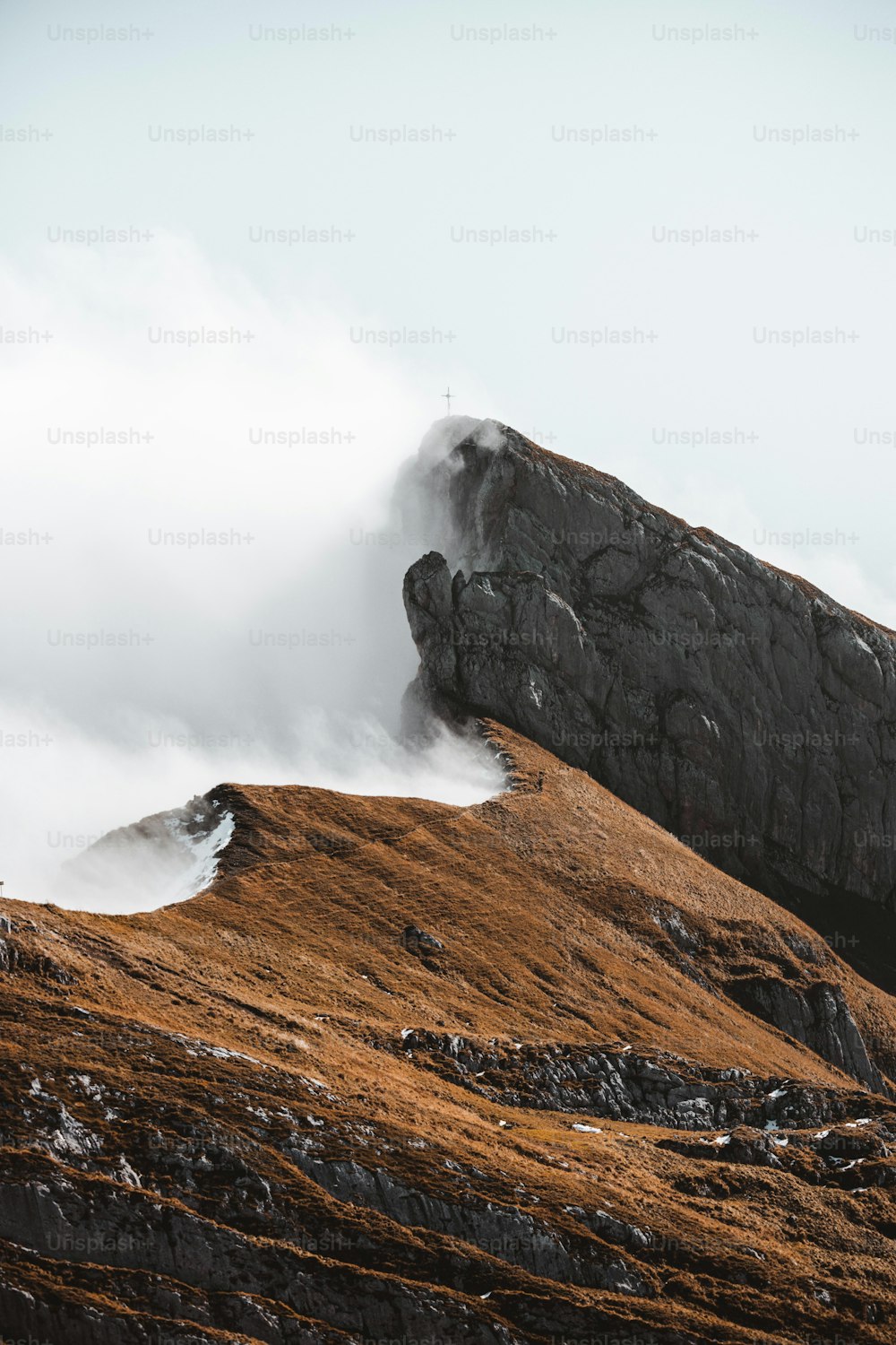 uma pessoa em pé no topo de uma montanha com uma prancha de surf