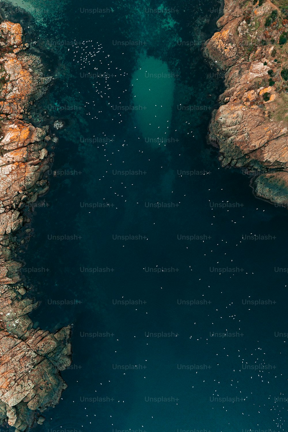 an aerial view of a body of water surrounded by rocks