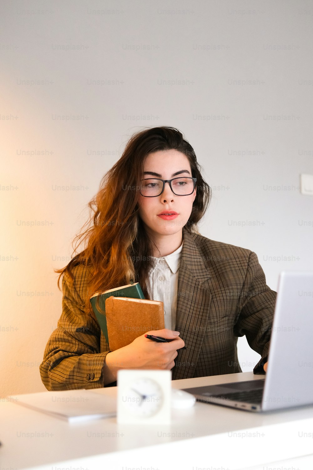 Una mujer sentada en un escritorio frente a una computadora portátil
