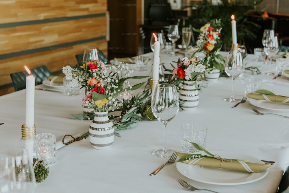 a table with a white table cloth and white candles