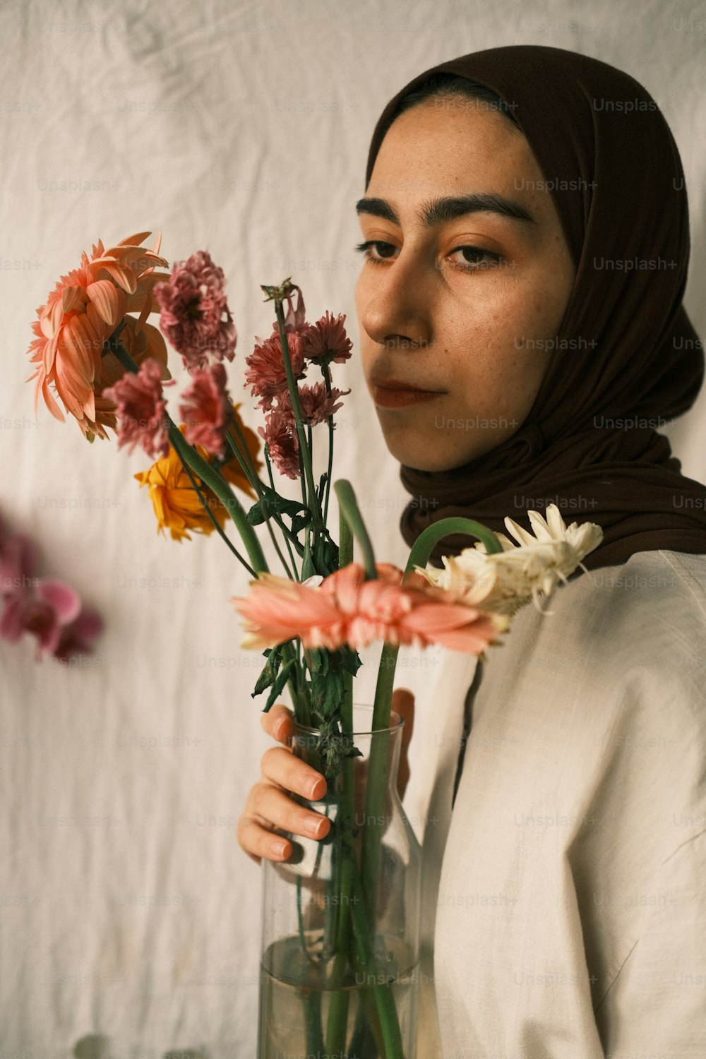 a woman holding a vase with flowers in it