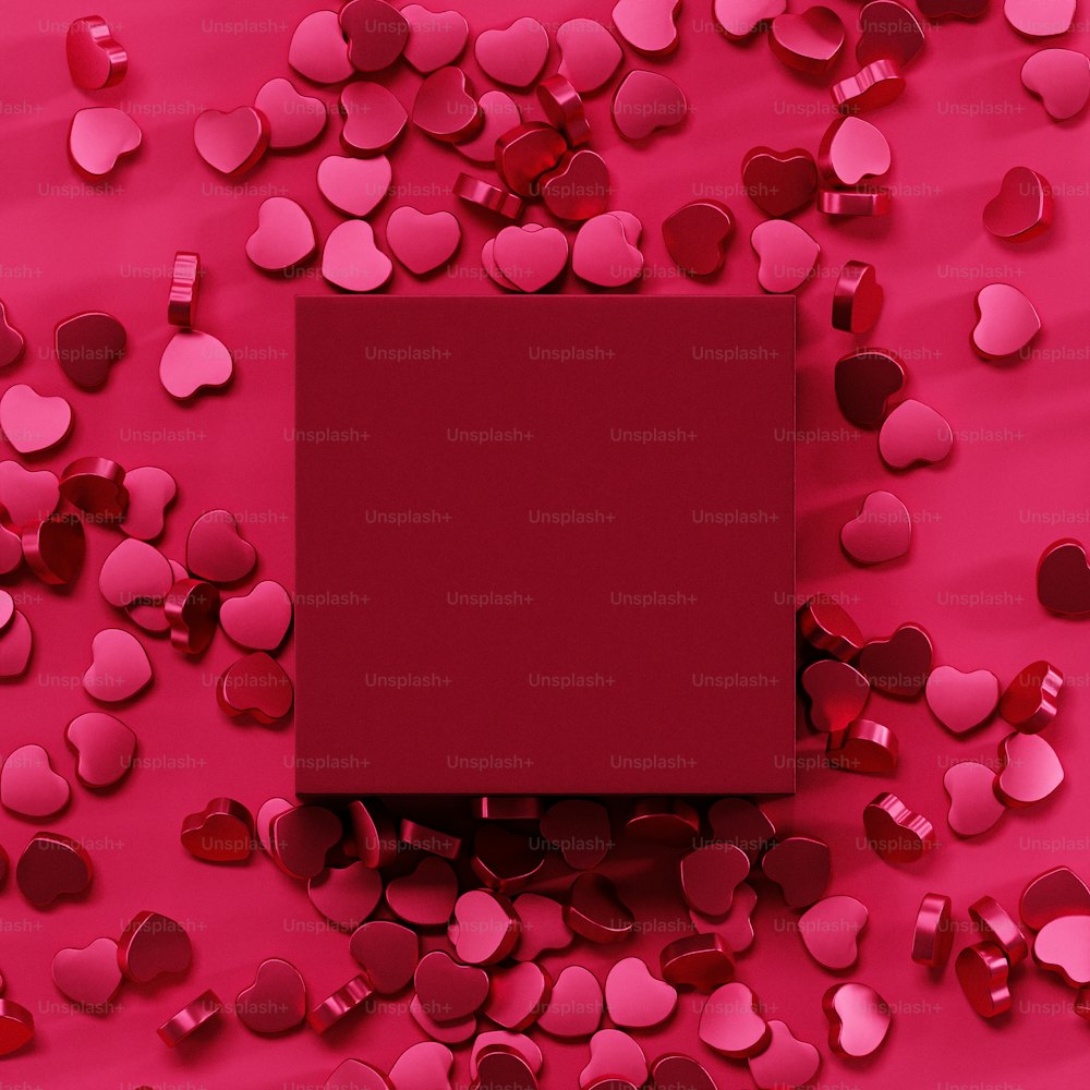 uma caixa vermelha cercada por corações em um fundo rosa