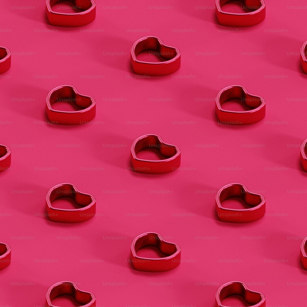 um grupo de objetos vermelhos em forma de coração em um fundo rosa