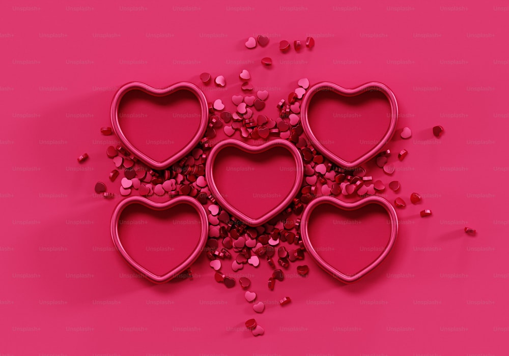 um monte de corações em forma de cortadores de biscoito em um fundo rosa
