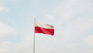 a flag flying in the wind with a blue sky in the background