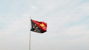 a flag flying in the wind with a blue sky in the background