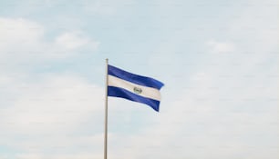 a flag flying in the wind with a blue sky in the background