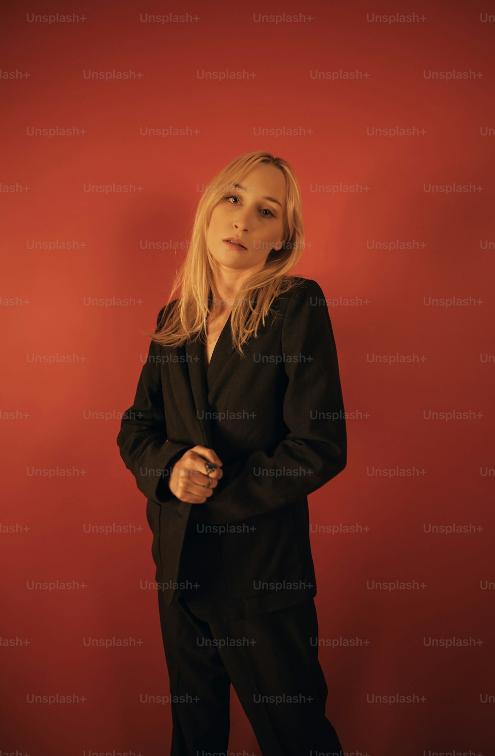 a woman standing in front of a red wall