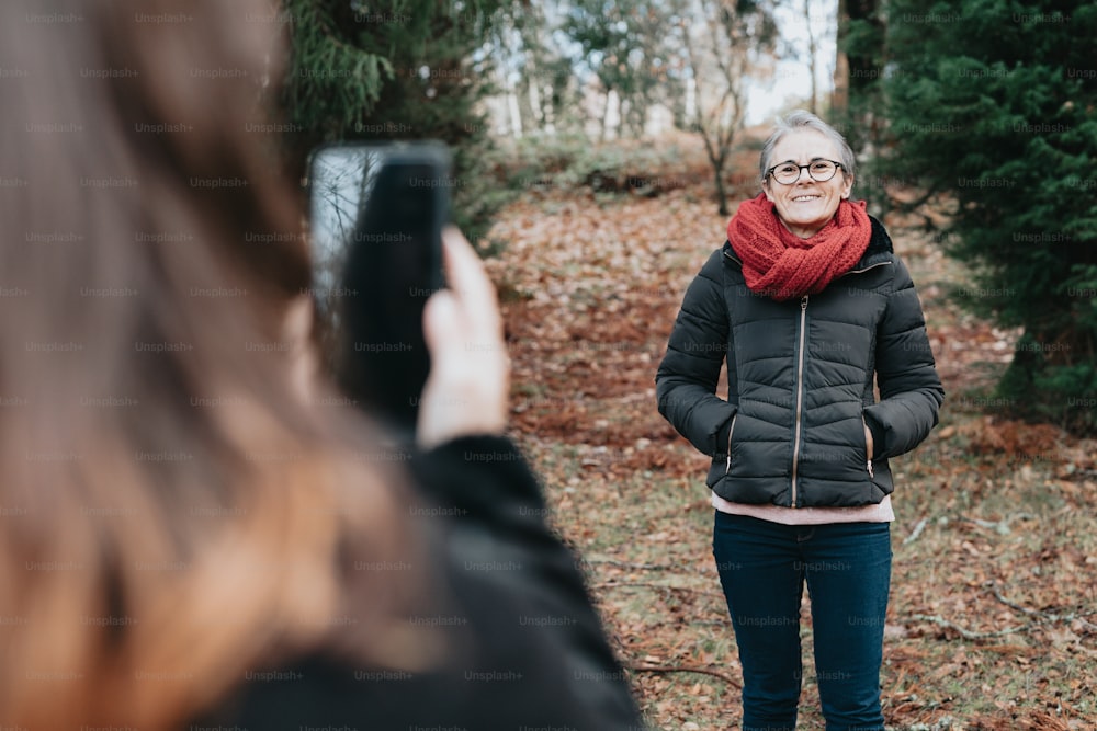 Eine Frau fotografiert sich im Wald