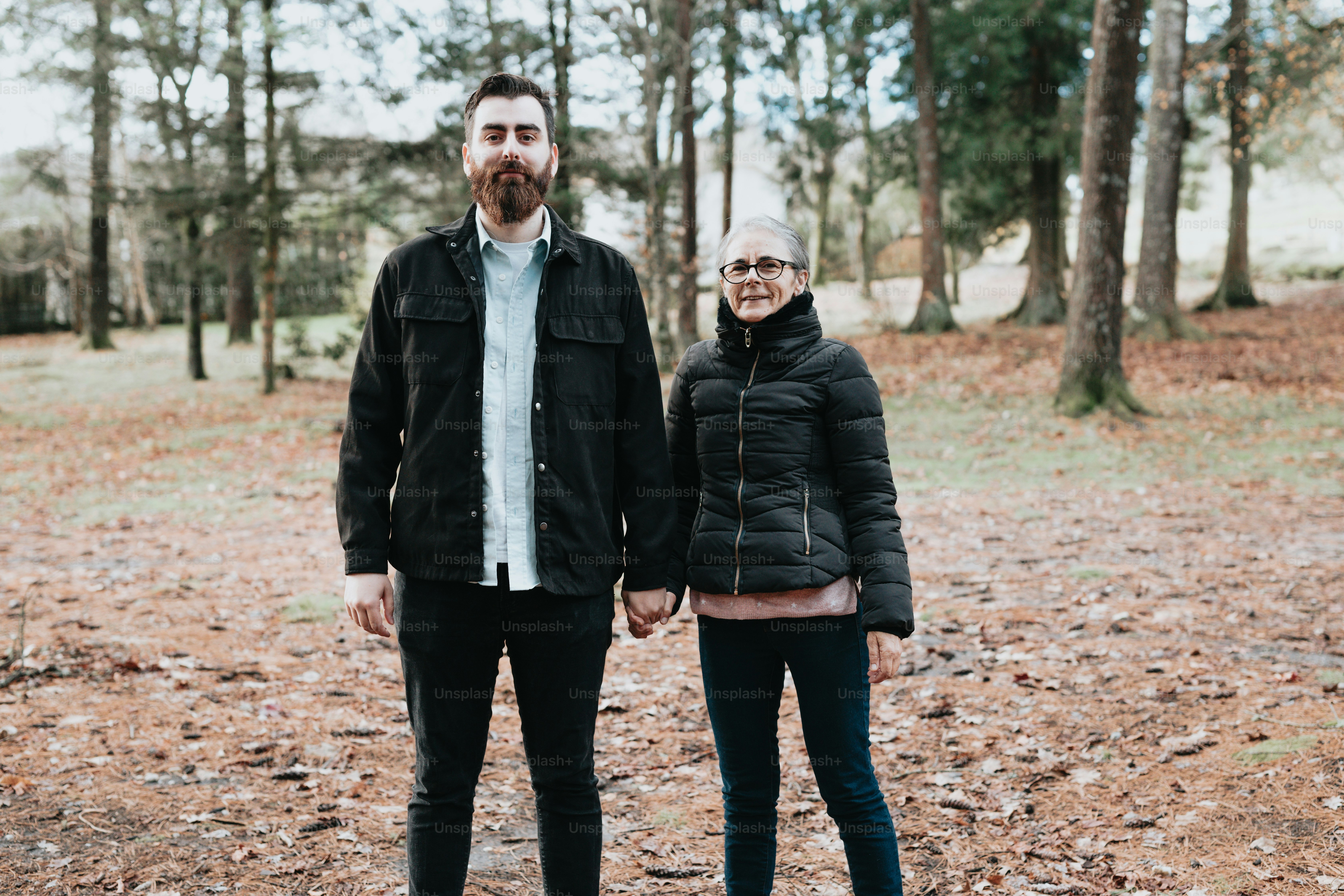 a man and a woman standing in the woods