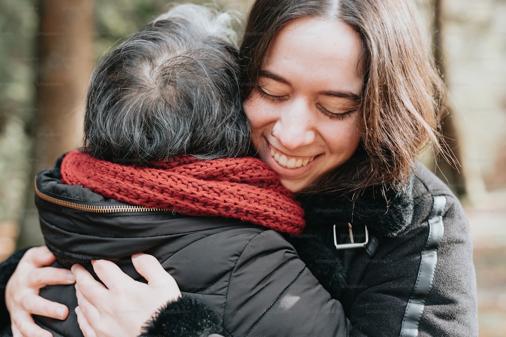 a woman hugging another woman in a park