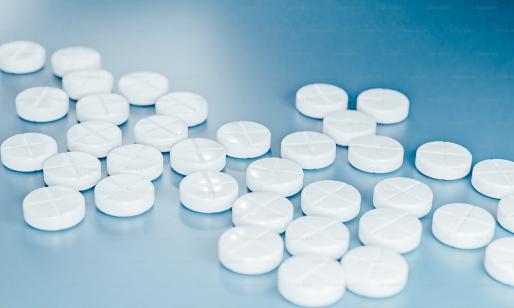 Un montón de píldoras blancas sentadas encima de una mesa