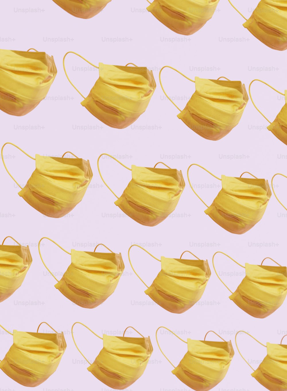 a group of yellow masks on a pink background