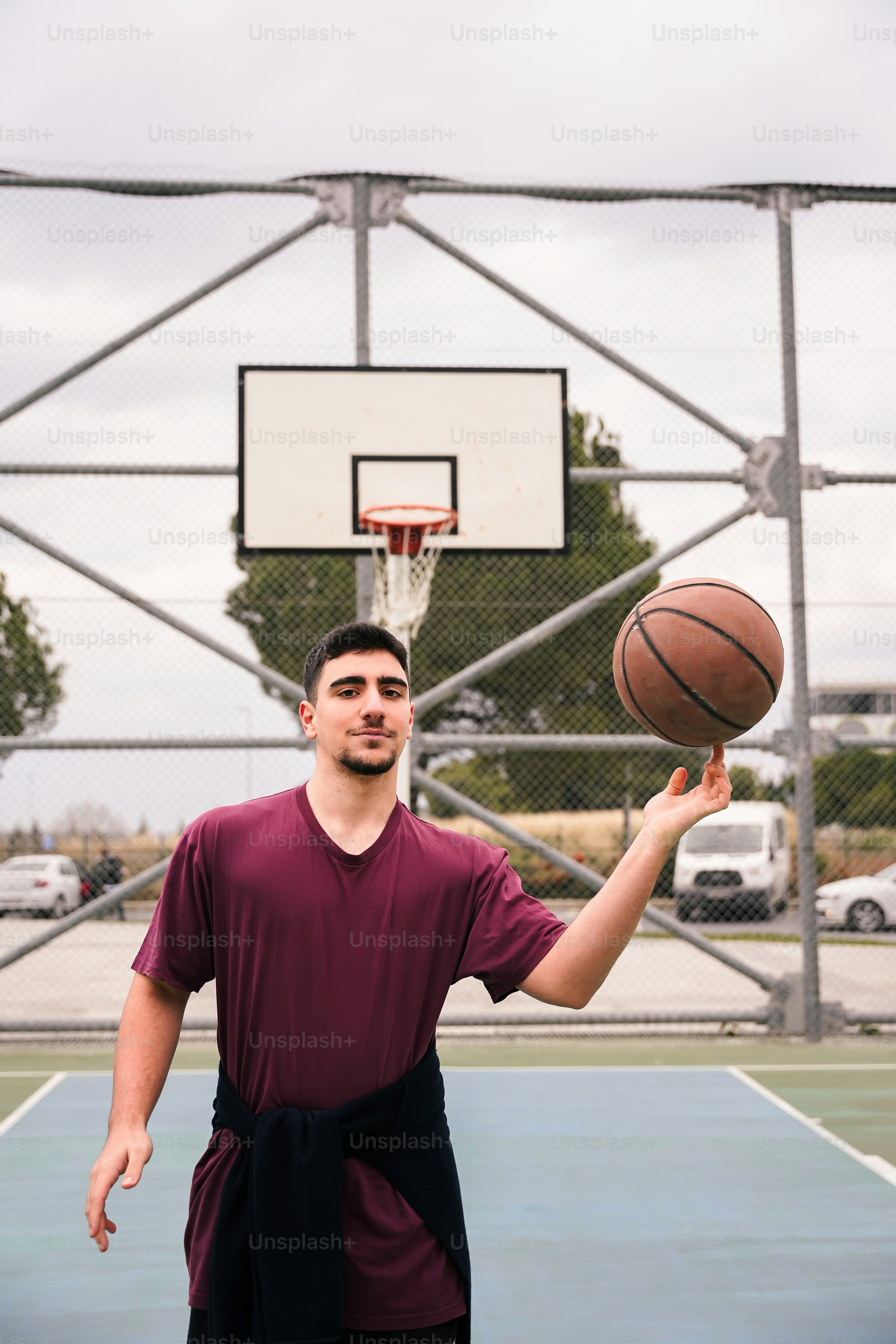 a man holding a basketball on top of a basketball court