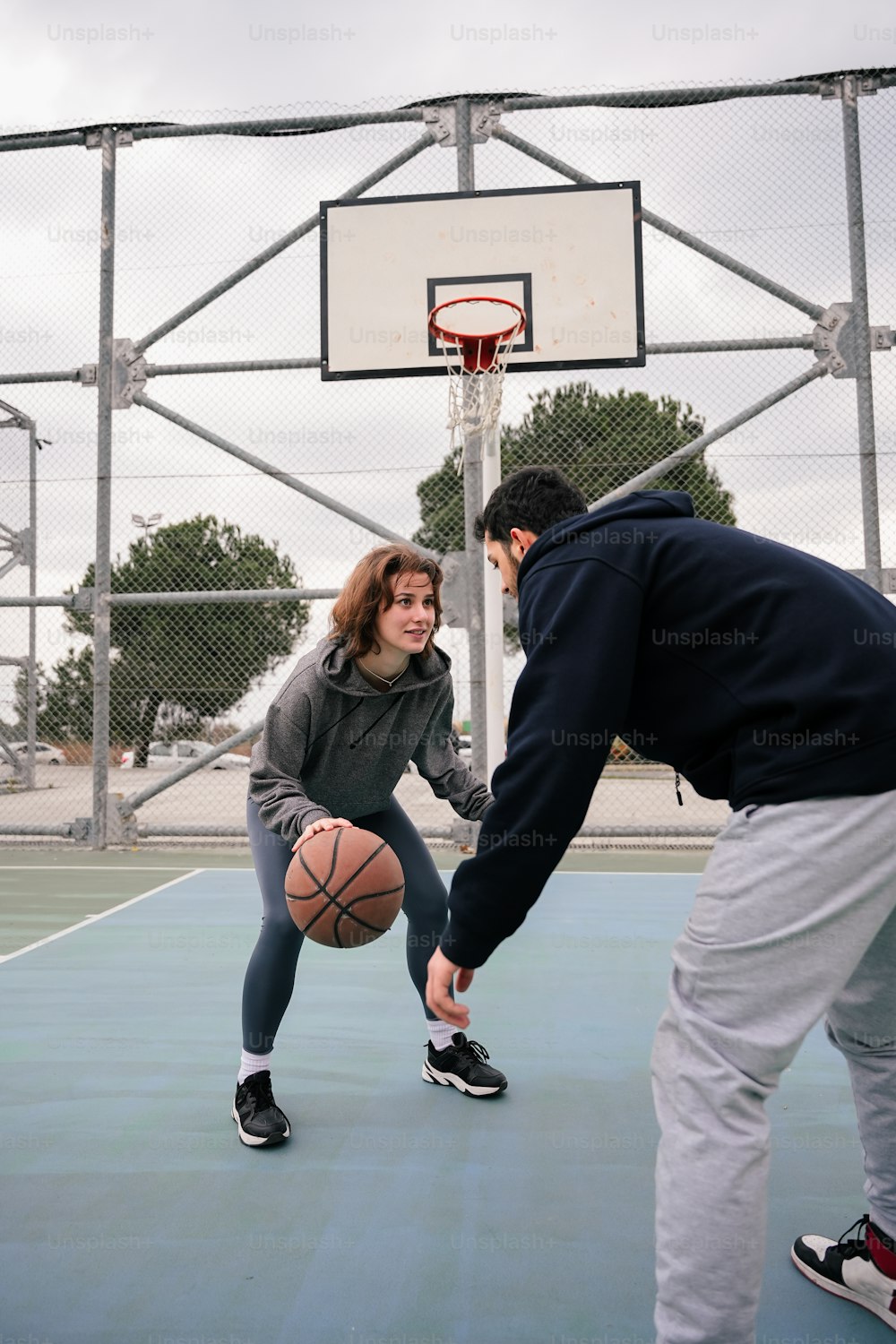 a man and a woman playing basketball on a court