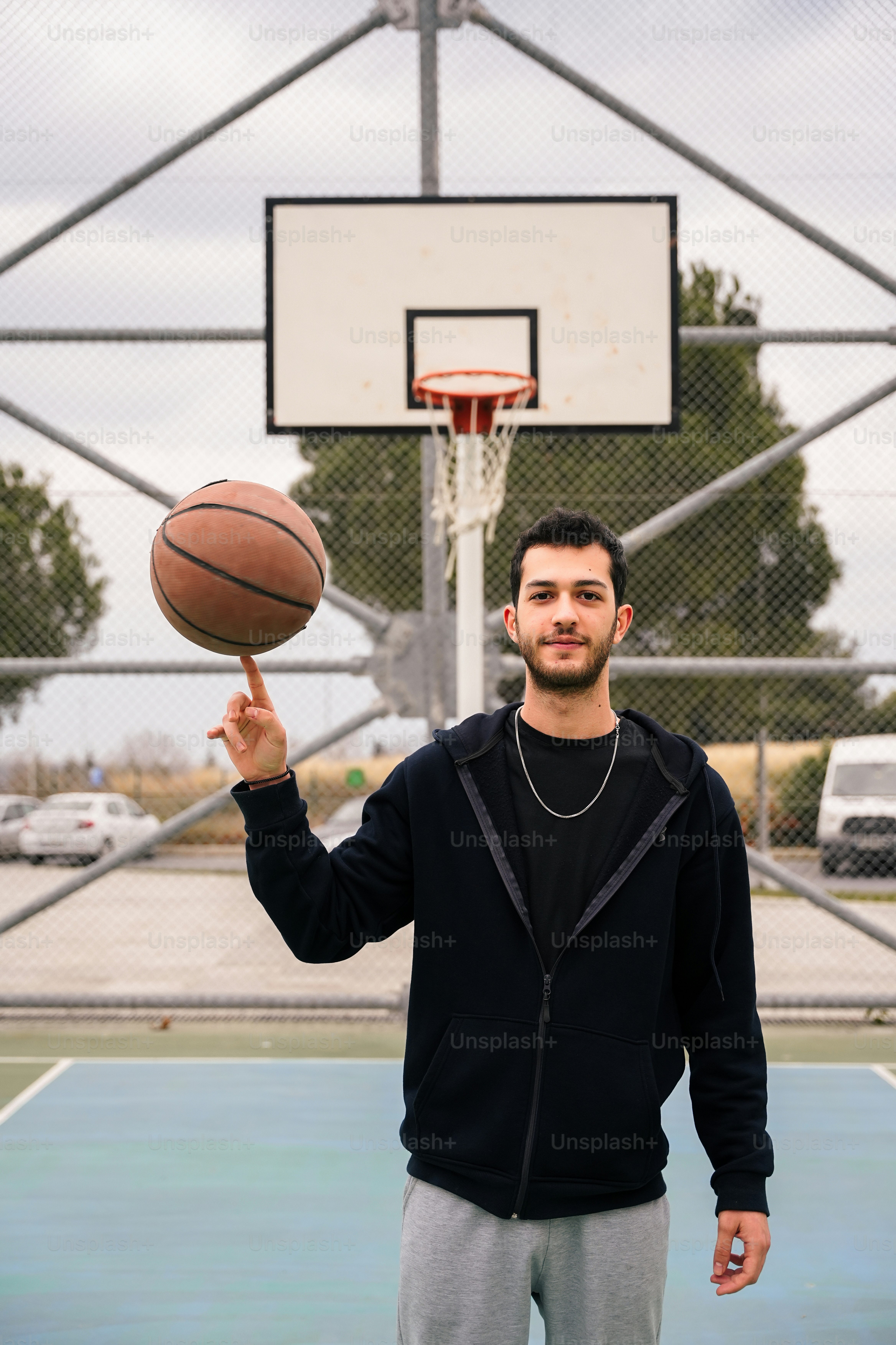 a man holding a basketball in front of a basketball hoop