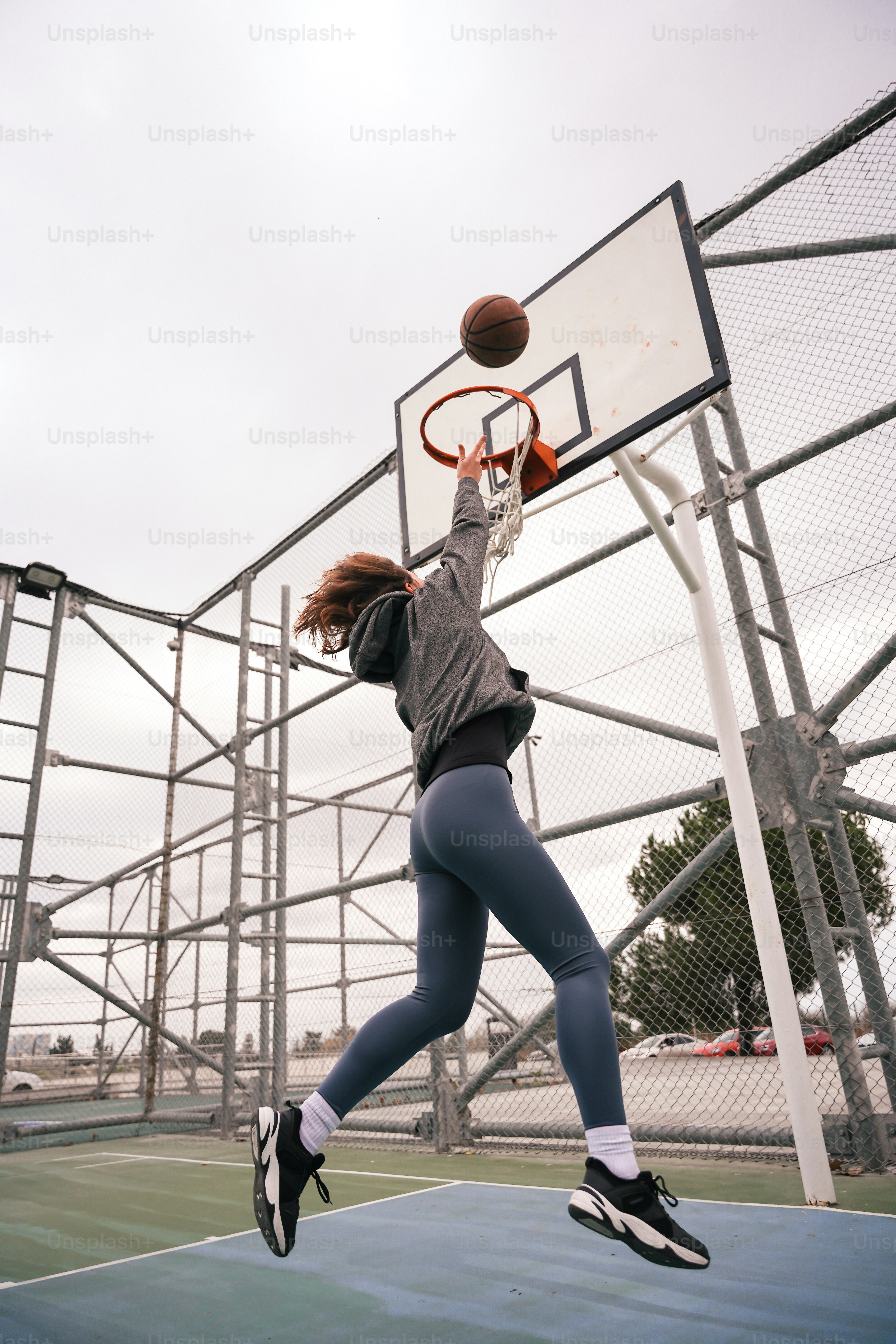 a woman jumping up to dunk a basketball