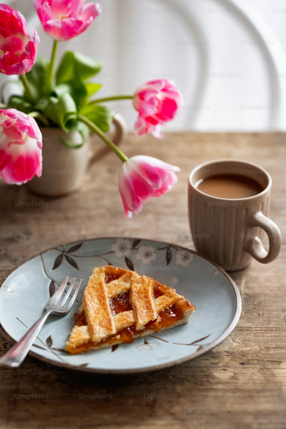 a piece of waffle on a plate next to a cup of coffee