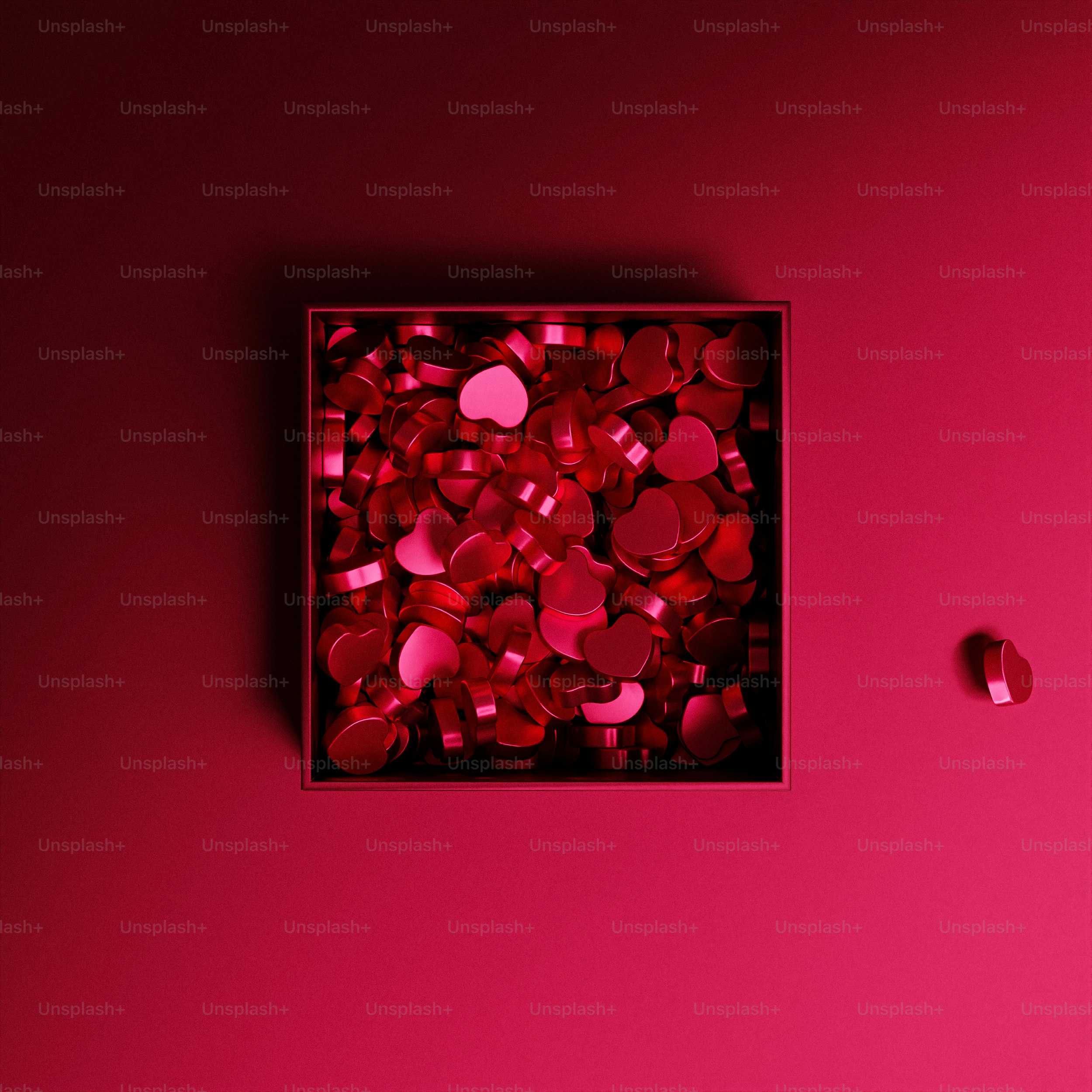 uma caixa de corações vermelhos em um fundo cor-de-rosa