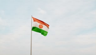 a flag flying in the wind with a sky background