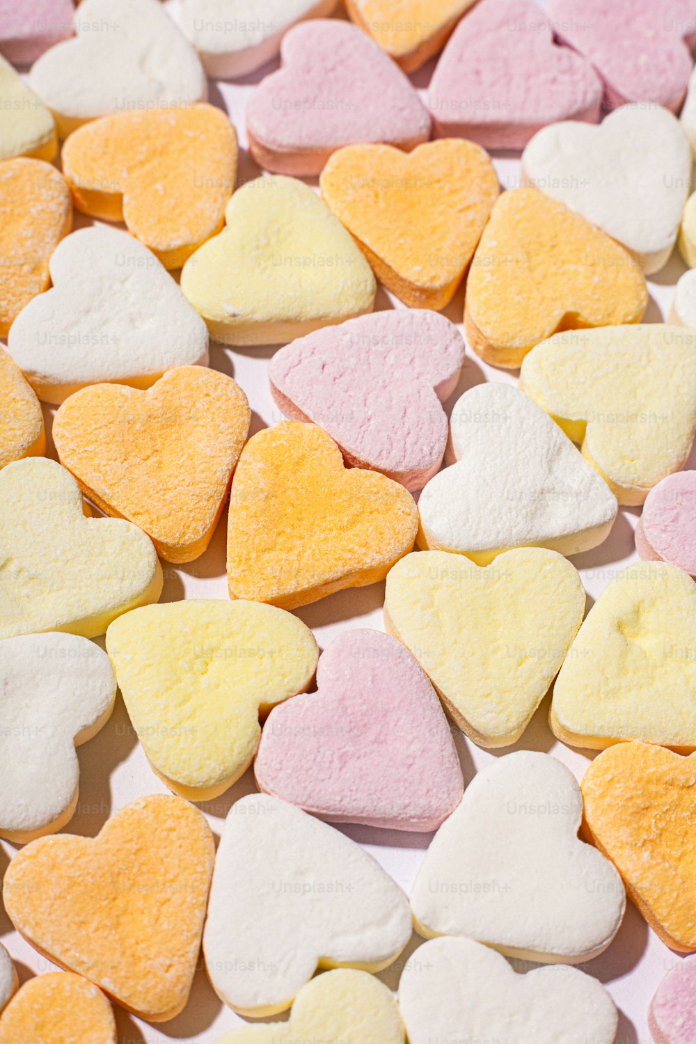 Un montón de galletas en forma de corazón sentadas encima de una mesa