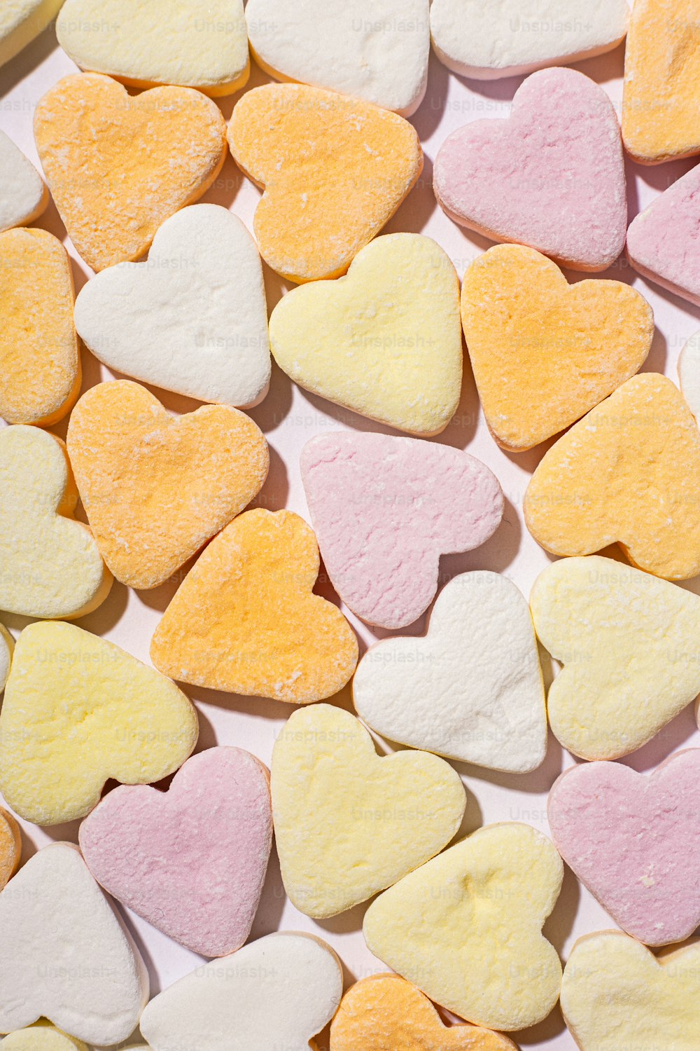Un montón de galletas en forma de corazón sentadas encima de una mesa