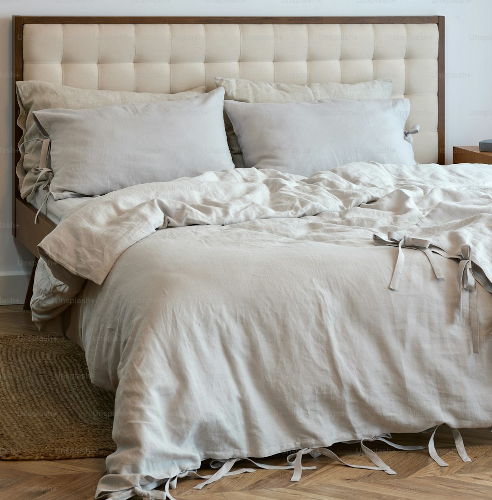 a bed with a white comforter and pillows