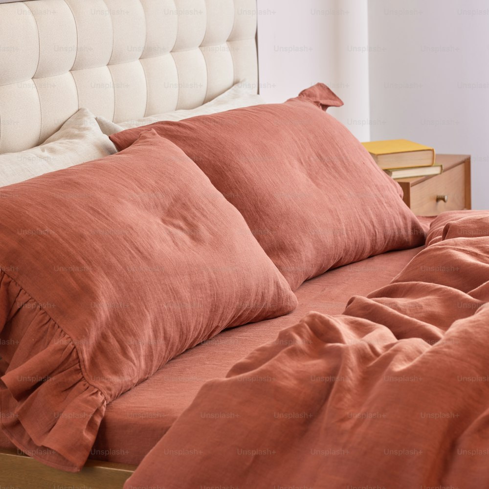 uma cama com dois travesseiros e um cobertor em cima dela